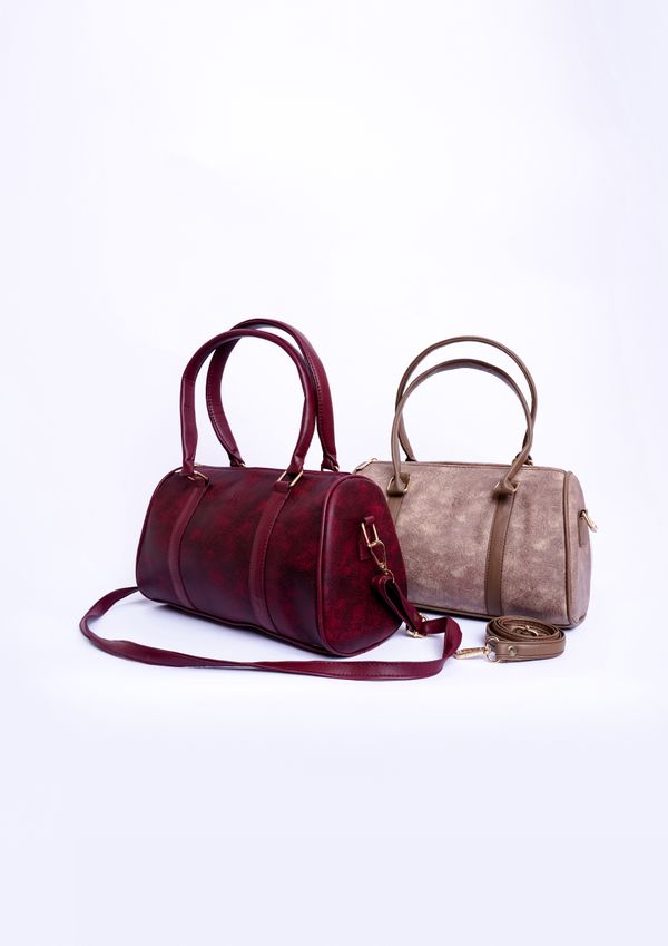Two barrel-shaped shoulder bags on a pale studio sweep — photo by Muneeb Malhotra on Pexels