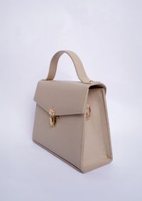 Beige flap crossbody bag on a white studio backdrop — Muneeb Malhotra on Pexels