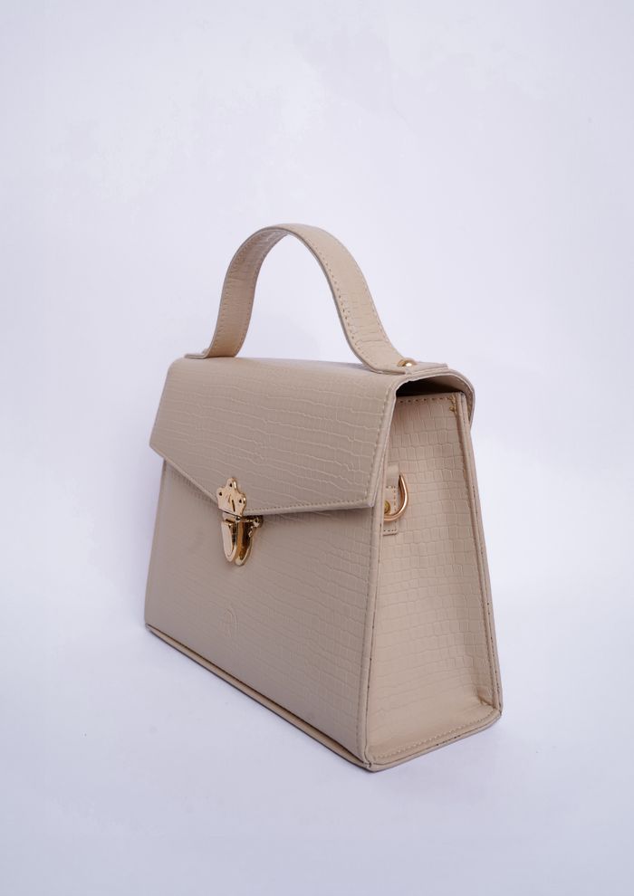 Taupe leather top-handle bag on a pale backdrop — photo by Muneeb Malhotra on Pexels