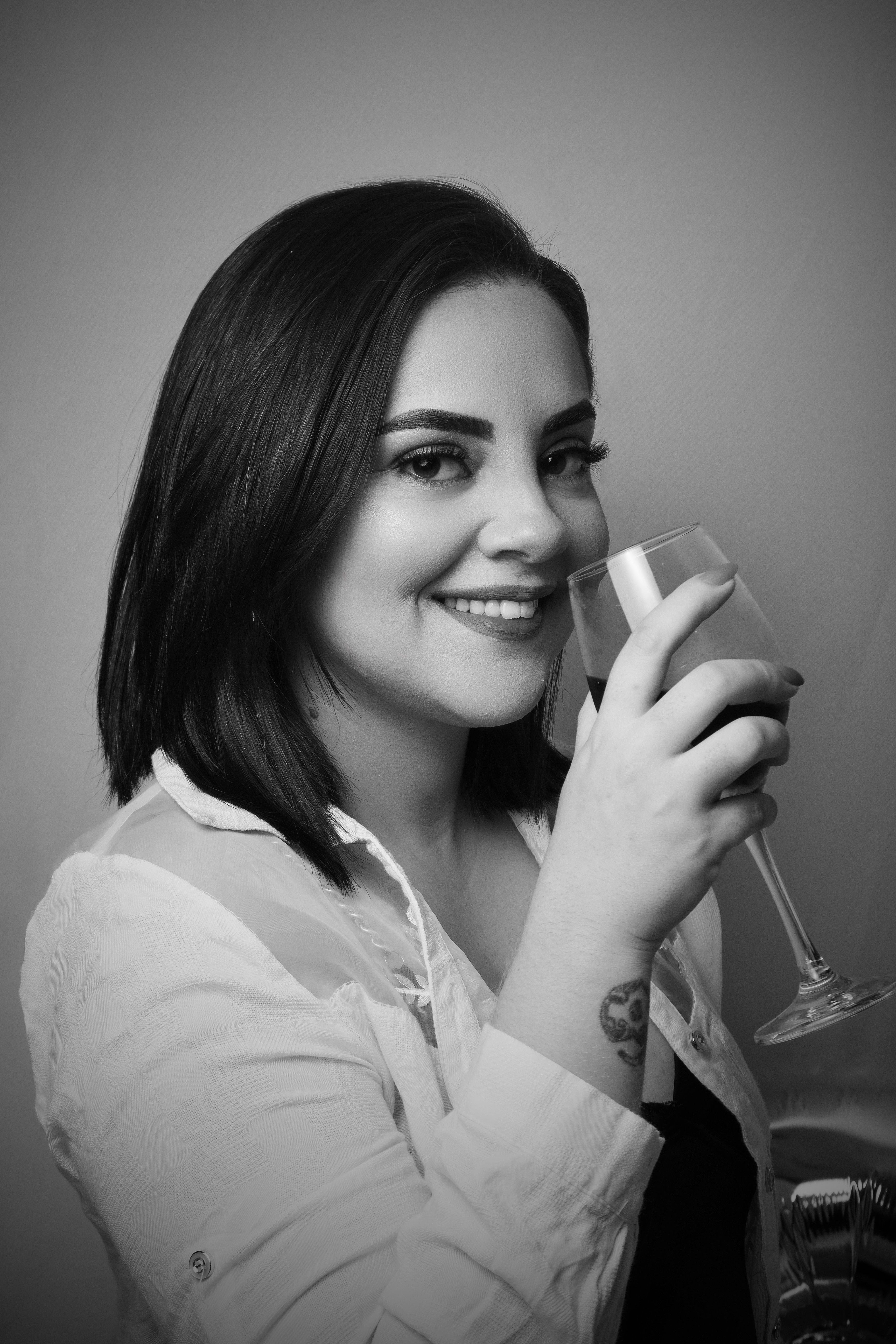 A woman is smiling while holding a glass of wine · Free Stock Photo