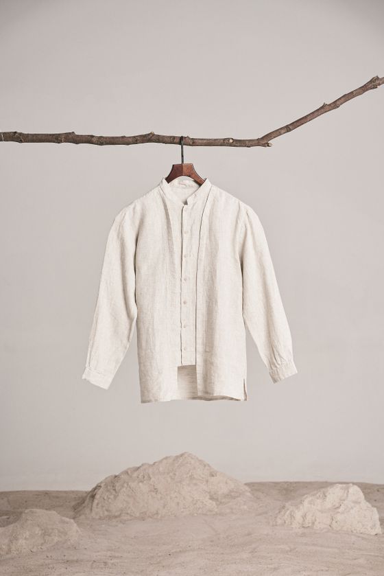 Sandwash linen overshirt hung from a branch rail in a studio — dayong tien on Pexels