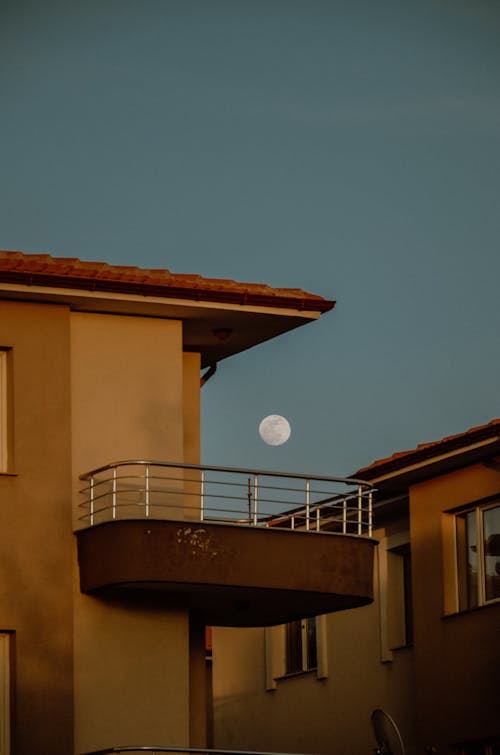 A full moon is seen over a balcony