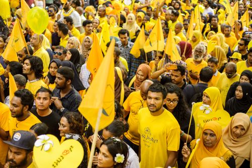 Free A large crowd gathers for a lively political rally, featuring yellow flags and attire, symbolizing unity and support. Stock Photo