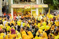 一群穿着黄色主题服装和标志的人们，正参加一场色彩缤纷、充满活力的街头游行