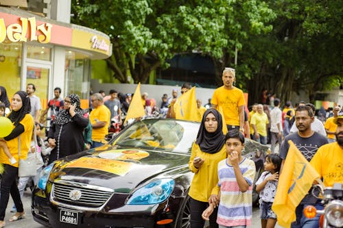People Standing While Wearing Yellow Shirts