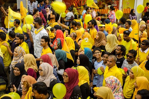 People Gathering Holding Flags and Balloons