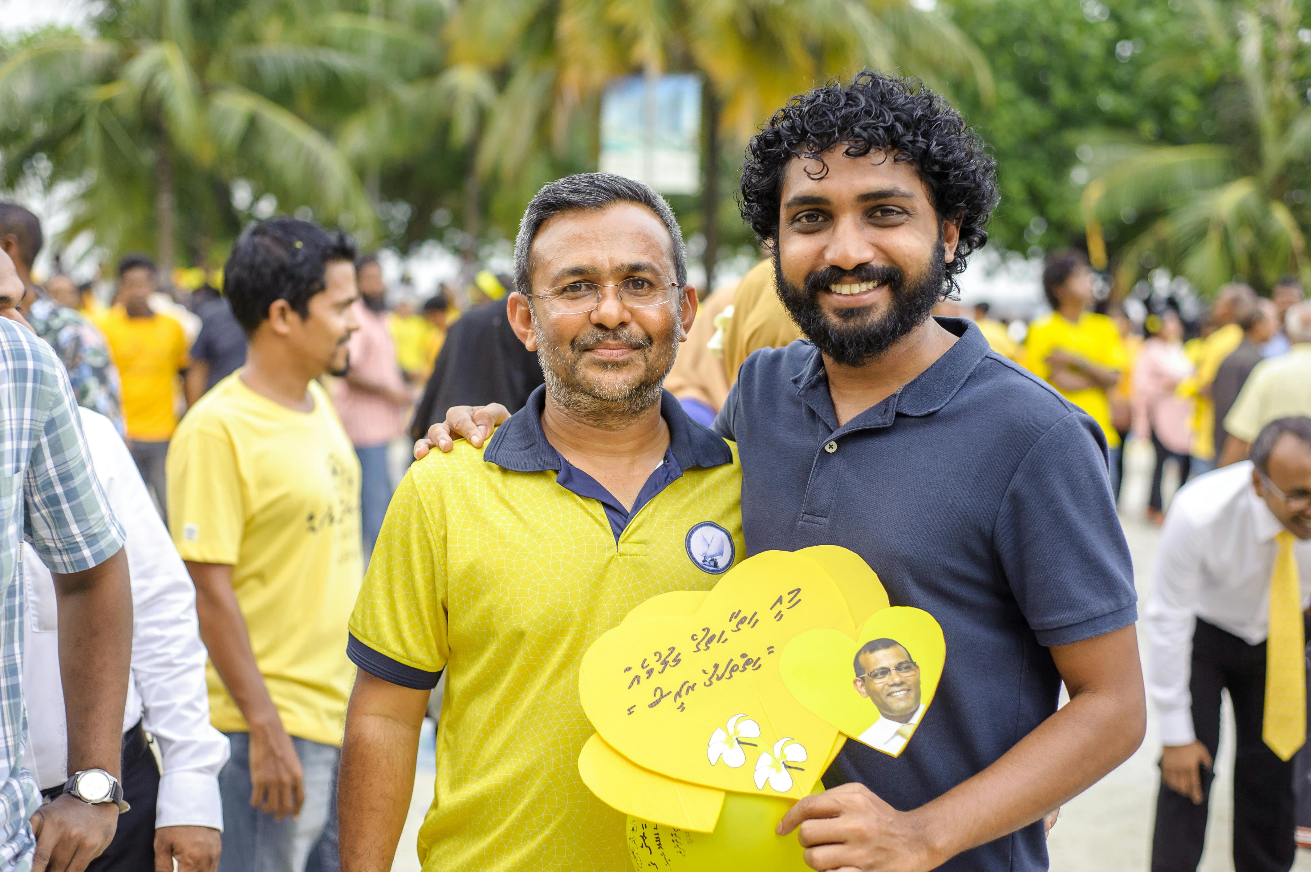 一场热闹的户外聚会上，人们身着黄色服装，享受着阳光明媚的一天