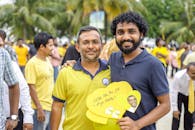 一场热闹的户外聚会上，人们身着黄色服装，享受着阳光明媚的一天