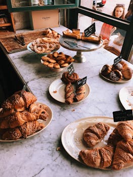 A mouth-watering display of various pastries including croissants and pastries in a bakery setting.