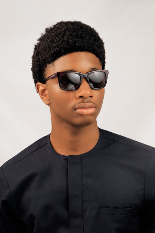A young man with sunglasses on and a black shirt