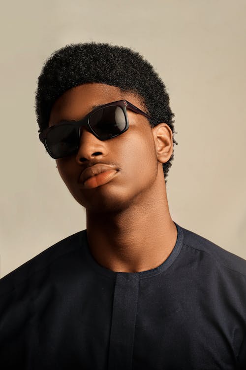 A young man with sunglasses on and a black shirt