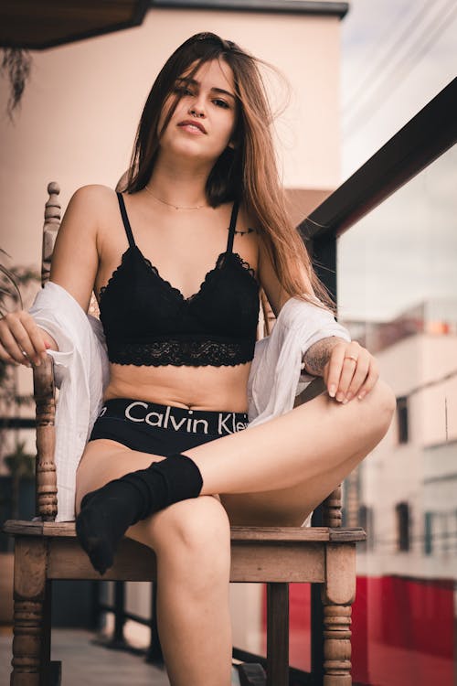 免费 坐着女人穿着黑色calvin Klein Pantie交叉腿 素材图片