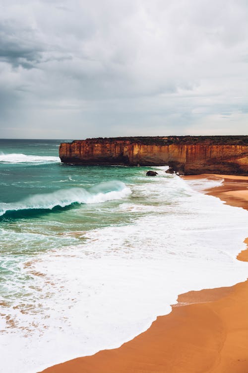 Scenic View Of Beach Under Cloudy Sky