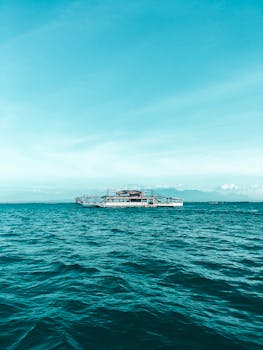 在菲律宾加的斯市宁静的海景中，一艘船航行于平静的蓝色水域之上