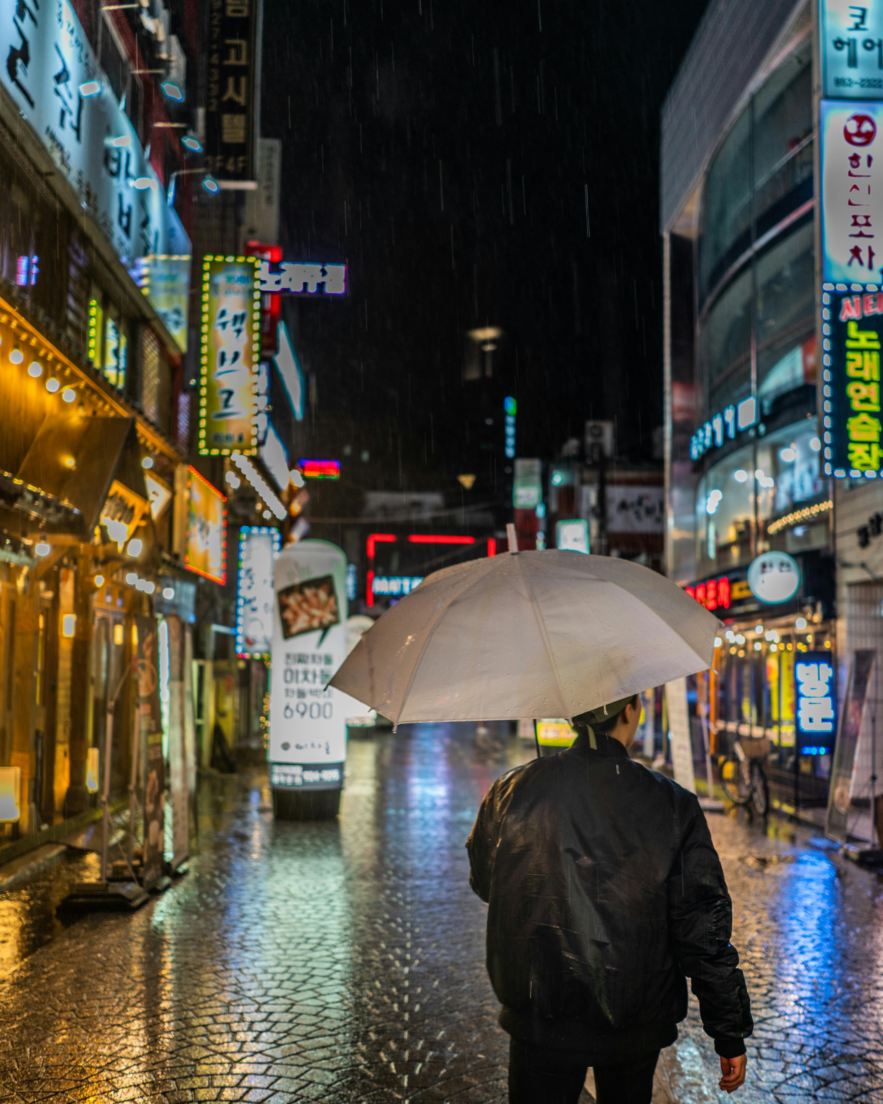 man wearing black jacket holding umbrella