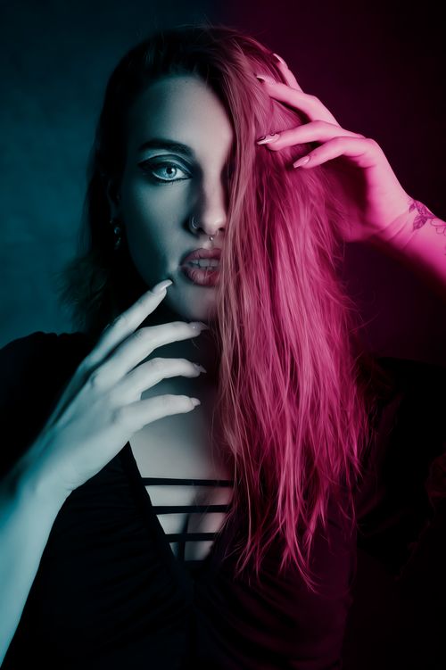 Free Dramatic portrait of a young woman with vibrant pink hair and nose ring, showcasing unique style. Stock Photo