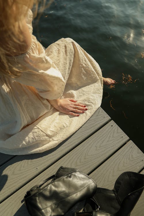 Woman in White Dress Sitting on Pier