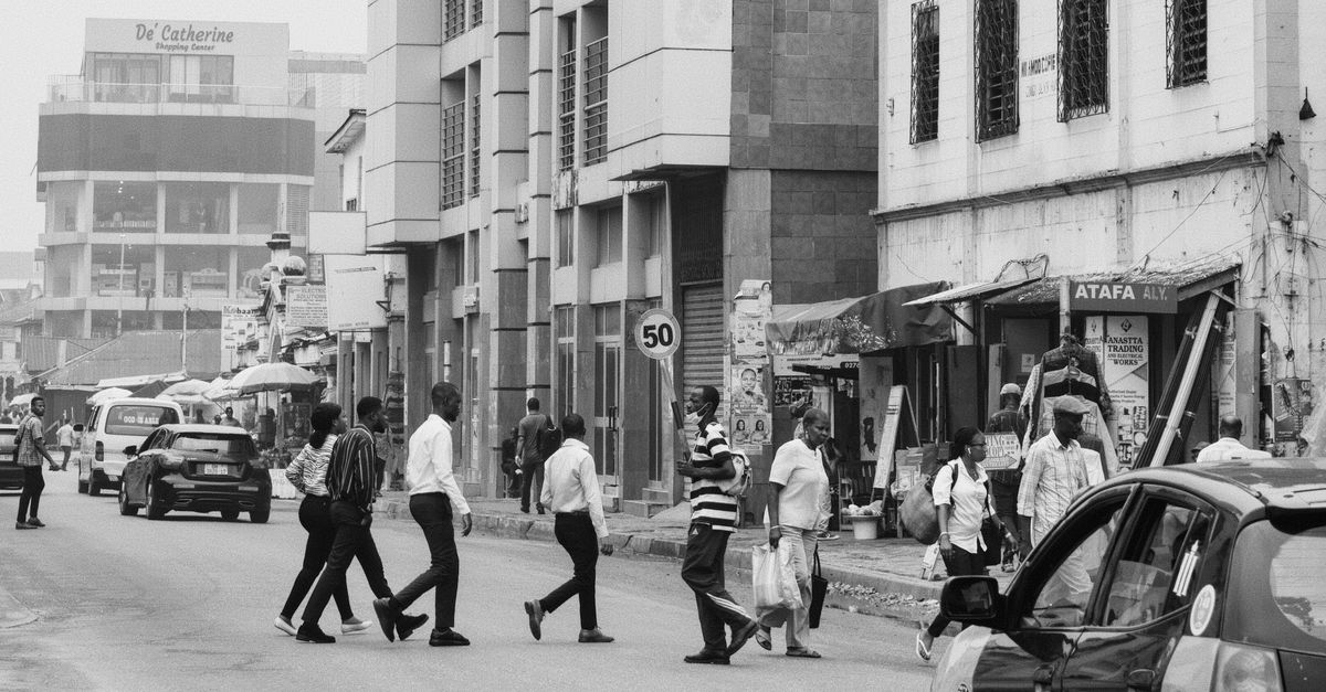 Street view of Barracks Newtown neighborhood in Ho, Ghana with churchgoers walking