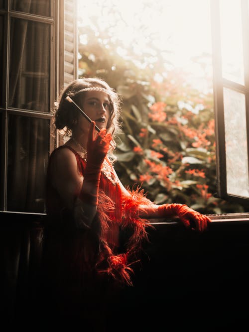 A woman in a red dress smoking a cigarette