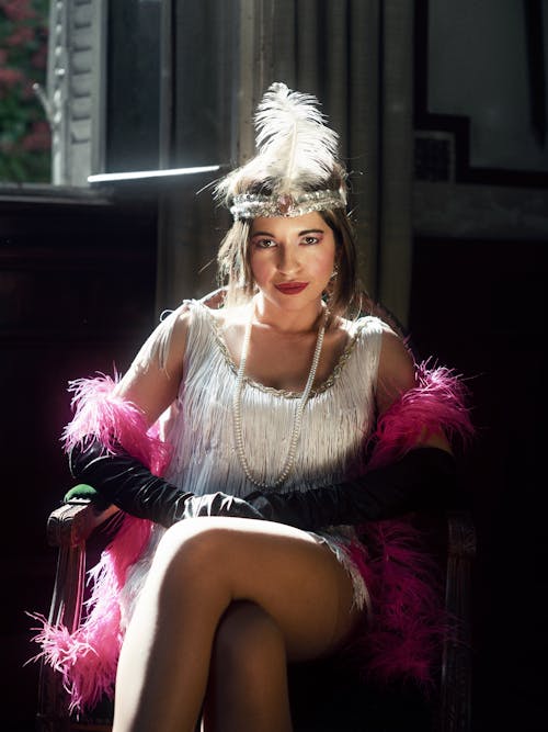 A woman in a flapper costume sitting in a chair