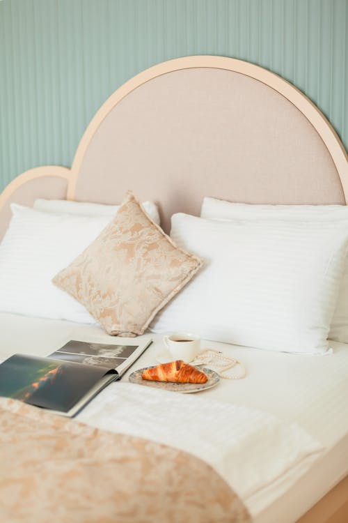 Free Book, Croissant and Beverage on Bed Stock Photo