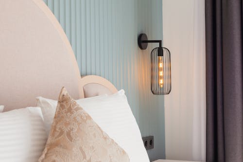 A bed with a lamp and pillows on it
