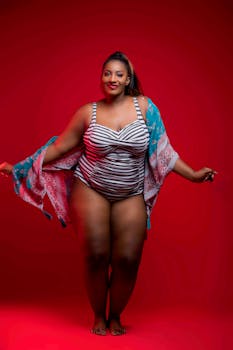 一位穿着条纹泳衣与和服的时尚女子，在红色背景前自信地摆出姿势