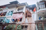 热闹的城区里，一位留着长发的时尚女人靠在栏杆上