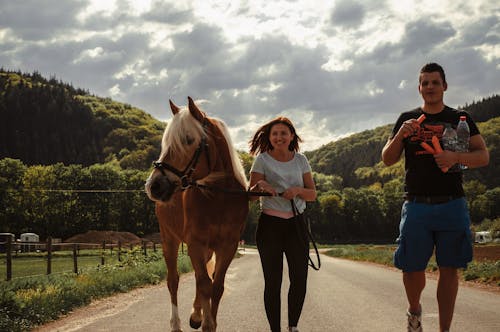 Mulher Caminhando Entre Um Cavalo E Um Homem