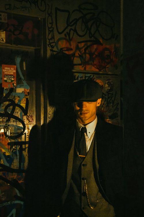 Free Dark and moody portrait of a man in vintage fashion, surrounded by urban graffiti. Stock Photo