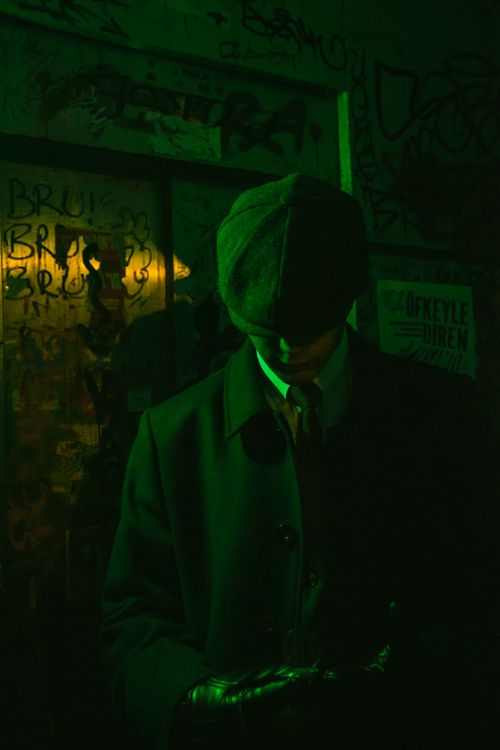 Free Portrait of a man in vintage attire under moody neon lighting, creating a classic and mysterious vibe. Stock Photo