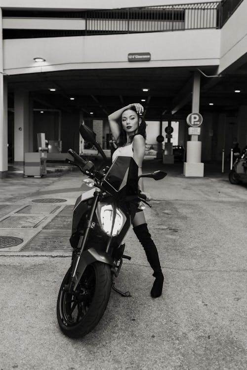 Free Woman in Over-the-knee Boots Posing on a Motorcycle Stock Photo