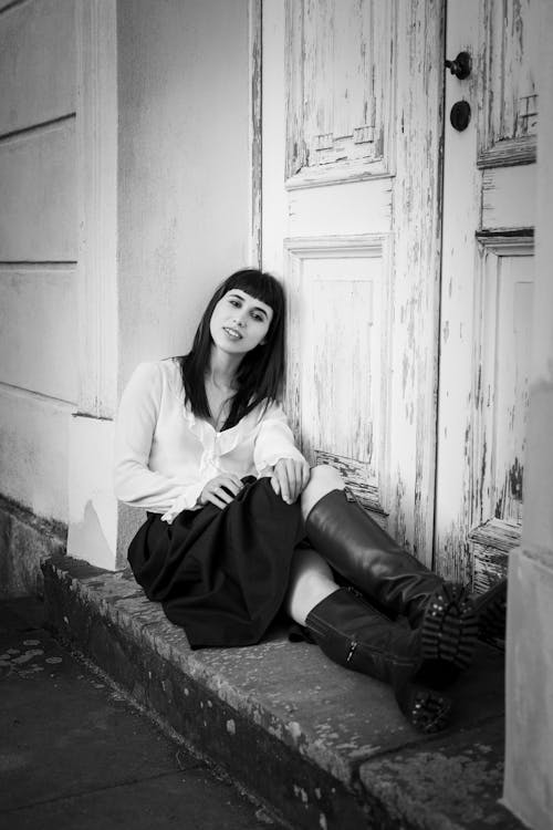 Foto d'estoc gratuïta de assegut, blanc i negre, botes de cuir