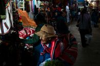 Elderly woman shopping at a vibrant market in Cusco, Peru.