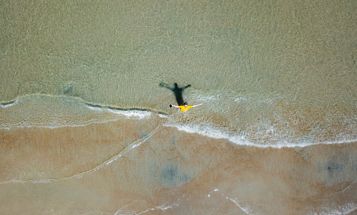 Free Aerial Photography of Man on Shallow Water Stock Photo