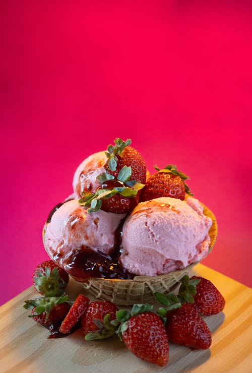A bowl of ice cream with strawberries on top