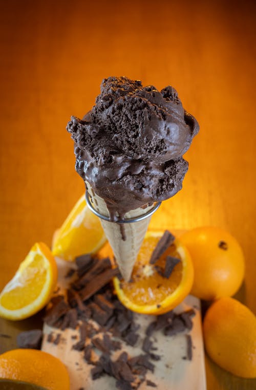 A scoop of chocolate ice cream with oranges