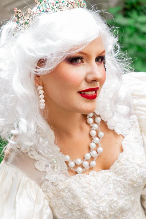 Free A captivating portrait of a woman dressed as a princess with a pearl necklace and tiara. Stock Photo