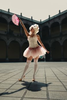 Ballerina in a delicate costume dancing in a historic courtyard in Mexico City.