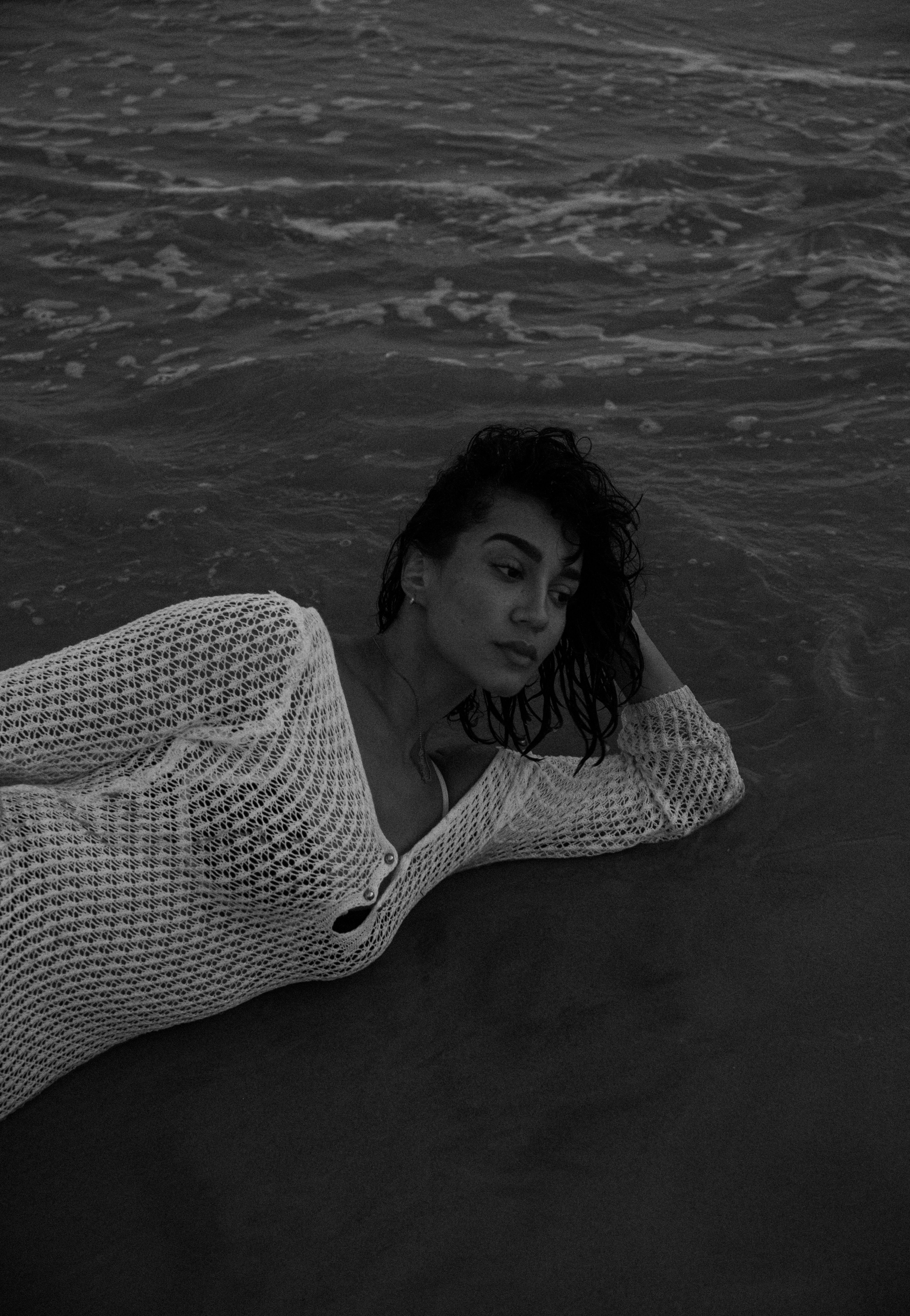 Woman Lying on a Beach in Black and White · Free Stock Photo