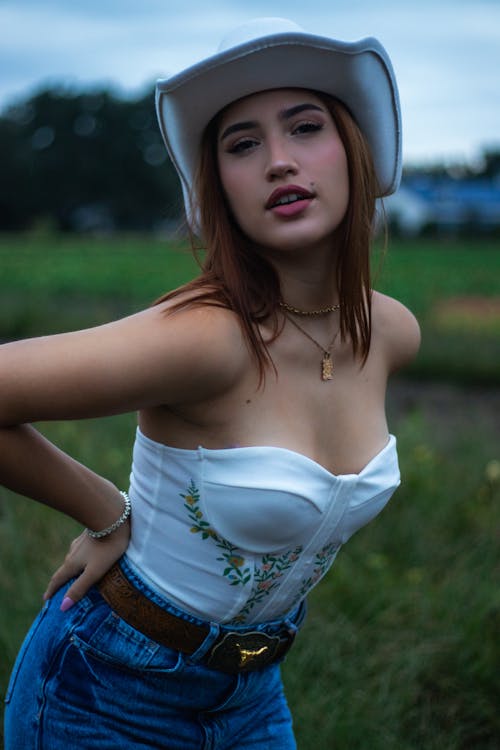 A young woman in a white hat and jeans