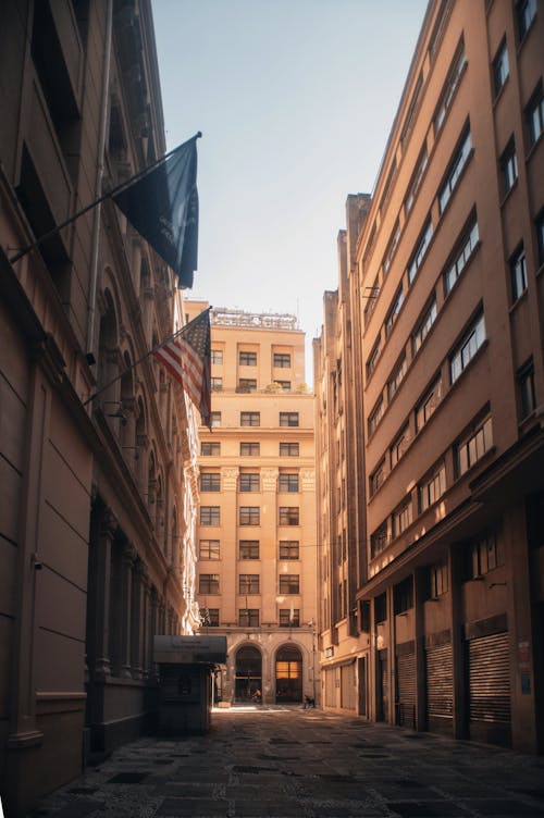 A photo of an alley with buildings and flags