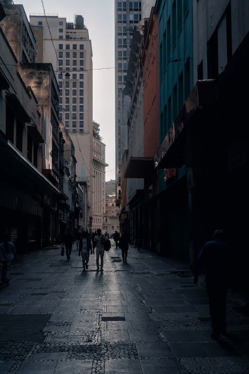 People walking down a city street with tall buildings