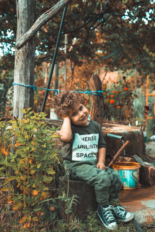 Free Smiling Boy Sitting on Brown Stool Stock Photo