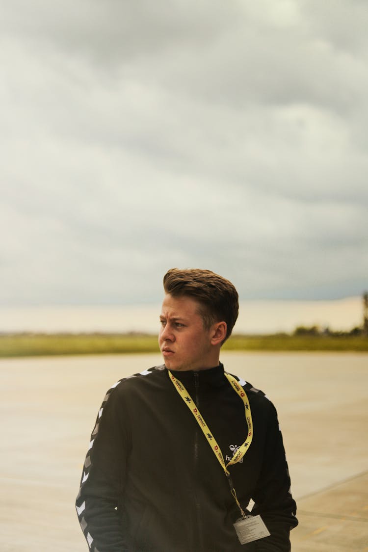 Photo Of Man In Black Jacket Wearing Yellow Lanyard Looking Away