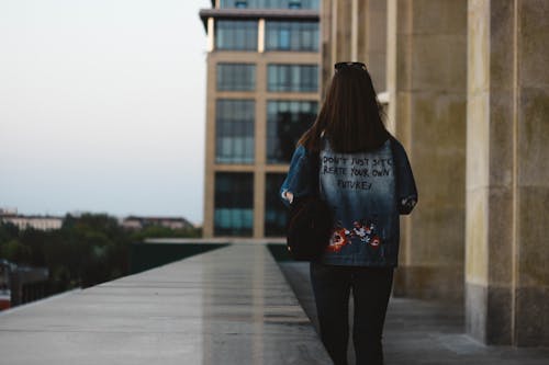 Back View Photo of Woman Walking Near Building