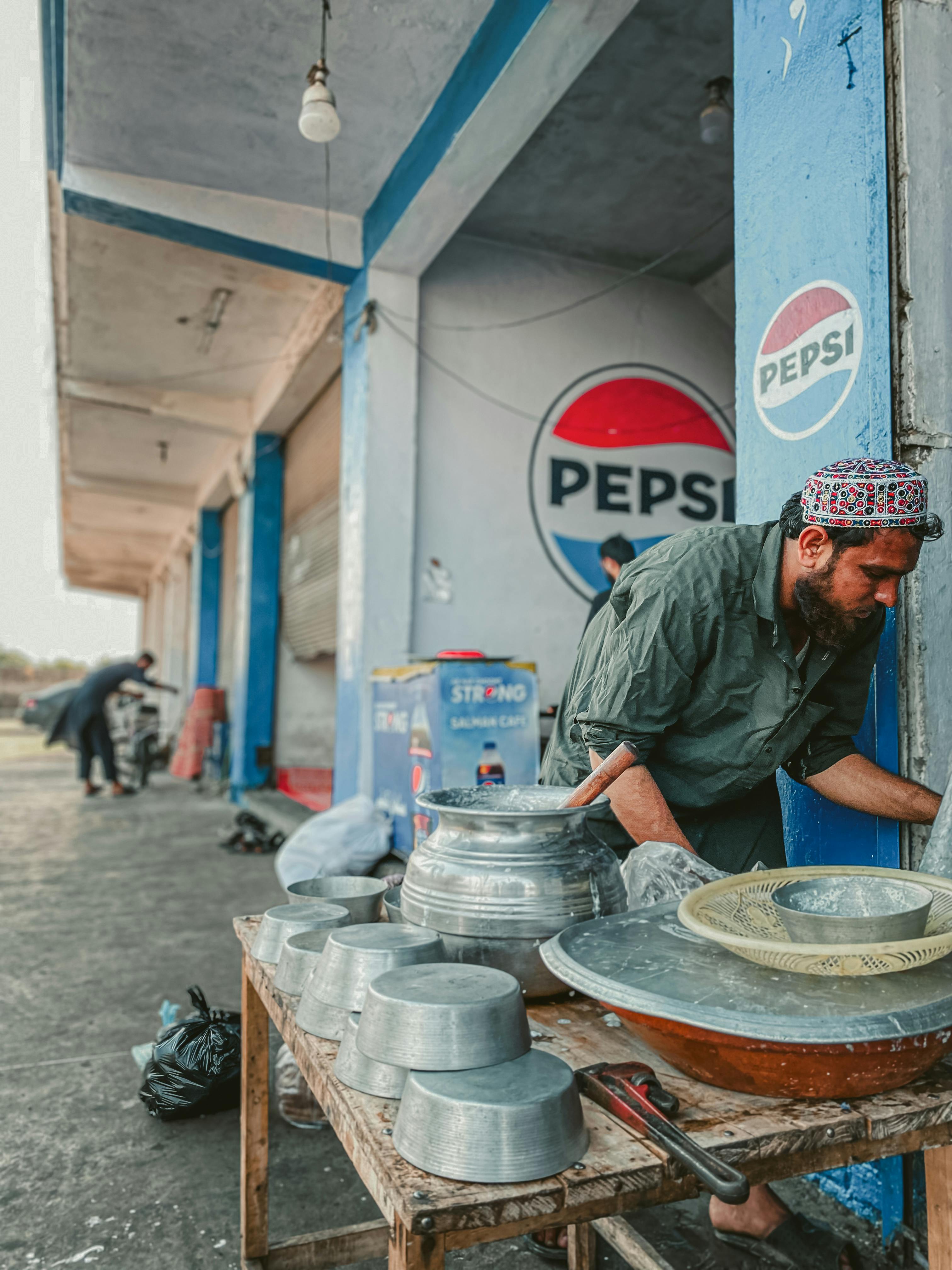 man working at table with pots