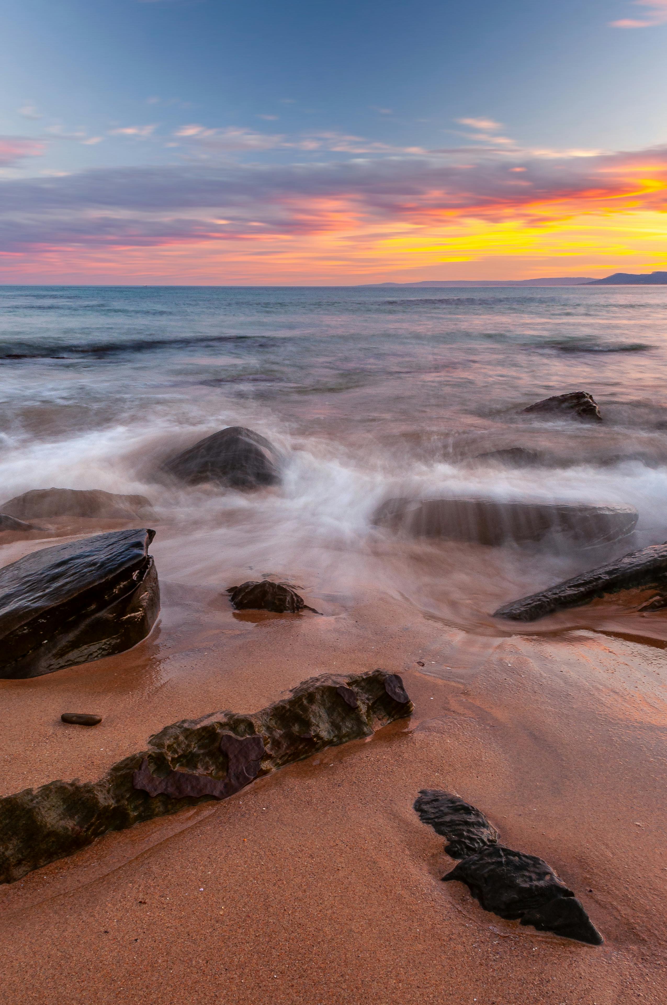 Vibrant sunset over Garie Beach's rocky shore in NSW, Australia. Perfect for nature lovers.