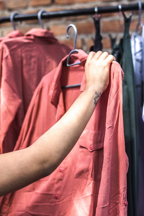 Free Person Holding Red Dress Shirt on Hanger Stock Photo