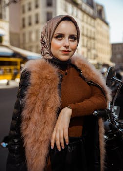 Elegant woman in Hijab and fur coat posing confidently on a street in Paris.
